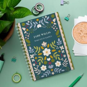 Evergreen personalised diary on a green background with a plant and a cup of hot chocolate