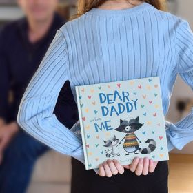 Child holding book behind back to gift to dad.